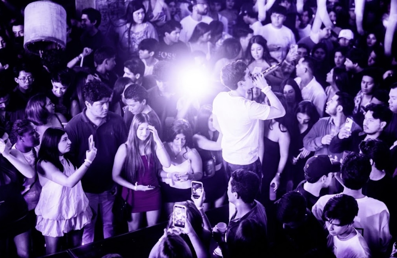 Kevin AMF presentándose entre el público bajo luz violeta